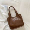 Dettaglio della borsa tote marrone intrecciata in ecopelle con motivo intrecciato classico - Marrone