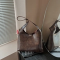Dunkelbraune Vintage-Eimertasche aus Kunstleder mit Golddetails und Plüschanhänger - Kaffee mit Anhänger