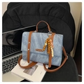 Detail of blue denim handbag with brown leather straps and wooden bead charm accessory - Blue - With Pendant / Blue