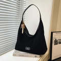 Sac hobo noir rétro en cuir mat avec pompon en perles de bois sur un livre blanc - Style Suède / Noir