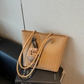 Light brown woven tote bag with slim leather straps and a cute plush bear charm - Khaki