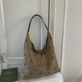Dettaglio dei motivi floreali tagliati al laser su borsa hobo in finta pelle scamosciata - Cachi