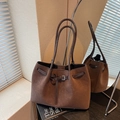 Vintage brown matte tote bag with slim handles and buckled strap detail in mirror reflection - Brown