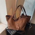 Bolso tote minimalista de ante marrón oscuro con tirantes finos en una elegante habitación - Marrón