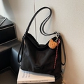 Grande borsa hobo nera opaca con ciondolo a orsetto e corda intrecciata su libri - Nero