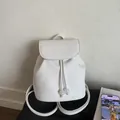 Detail eines weißen Lederrucksacks mit Kordelzug und eleganten Perlenverzierungen - Weiß