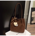 Close-up of brown suede bucket bag featuring a decorative white plush heart charm - Coffee with Pendant