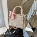 Beige tote bag with pink floral embroidery and a decorative silk bow on the handle - Off White