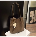 Détail du sac fourre-tout en daim marron avec pendentif cœur en peluche et bandoulière longue - Avec Pendentif / Vert