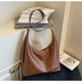 Detalle de bolso hobo marrón en piel sintética con correa ajustable y hebilla plateada - Marrón