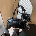Bolso Boston negro brillante con herrajes plateados reflejado en un espejo redondo - Negro