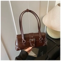 Nahaufnahme der braunen glänzenden Retro-Tasche mit Silbernieten und Metallschnalle Detail - Braun