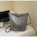 Detalle del bolso tipo cubo en cuero gris con logo FASHION & BAGS y diseño de doble asa - Plateado