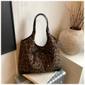 Detail einer Leopard-Tragetasche mit schwarzer Lederschleife und Griff auf dem Koffer - Schwarz