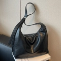 Bolso tote negro plisado de cuero PU con hebilla plateada sobre un libro blanco - Negro
