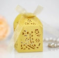 Dettaglio di motivi floreali tagliati al laser su scatola regalo gialla con nastro - Oro