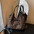 Grand sac cabas à imprimé léopard avec anses noires et nœud élégant reflété dans un miroir - Noir