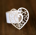 Détail d'un rond de serviette en papier blanc avec motif de cœur évidé et fleurs ciselées - Blanc