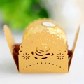 Macro shot of pearl gold laser-cut paper truffles holder with rose and star pattern - Gold