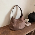 Sac hobo minimaliste en daim marron avec couture rétro sur une table en bois - Marron