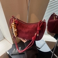 Borsa a mezzaluna in camoscio bordeaux con tracolla annodata e ciondolo etnico - Rosso