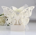 Detail of laser-cut white butterfly candy box with floral patterns and a silk ribbon bow - Starry White