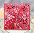 Elegant laser-cut red wedding invitation card with floral hollow design on a white plate - Pearlescent Red