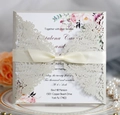 Détail d'invitation de mariage découpée au laser avec insert fleuri et ruban crème - Argenté