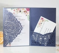 Macro detail of navy blue laser-cut wedding invitation with elegant floral inner card - Navy Blue Style