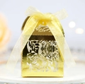 Detailed view of golden laser-cut wedding candy box with elegant floral hollow pattern - Reflective Gold