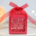 Macro detail of red laser-cut wedding favor box with floral patterns and a silk ribbon - Pearlescent Red