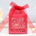 Detailed view of red laser-cut wedding favor box with elegant floral pattern and silk ribbon - Pearlescent Red