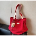 Close-up of red canvas tote bag with cream leather strap and cute plush dog charm - With Charm / Red with Pendant