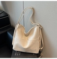 Detalle de bolso tote crema con correas ajustables y logo grabado en piel sintética suave - Blanco Roto