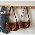 Détail de sacs croissants marron vintage avec porte-clés léopard en peluche sur crochet - Caramel Grand