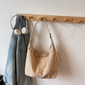 Minimalist beige suede dumpling shoulder bag with zip closure on a wooden hanger - Beige (No Pendant)