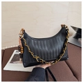 Détail du sac croissant tressé noir avec chaîne dorée et perles en bois sur canapé - Cuir PU Noir