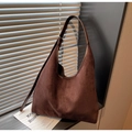 Primer plano detallado de un bolso Hobo de ante marrón oscuro con costuras y textura suave - café