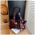 Détail macro du sac bandoulière en cuir brillant bordeaux avec boucle et grigri léopard - Bordeaux (Avec Pendentif Gland d'Ours)