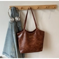 Détail grand sac fourre-tout vintage marron avec bande dorée sur un cintre en bois - Marron