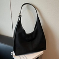 Bolso hobo retro de ante negro con correa ajustable en un entorno de estilo minimalista - Negro