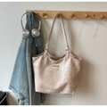 Détail du grand sac cabas en similicuir beige avec une plaque de logo en métal élégante - Blanc Cassé