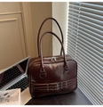 Dettaglio macro della borsa tote in pelle marrone lucida con cerniere e fibbie in argento - Marrone
