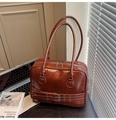 Dettaglio di una borsa tote in pelle lucida marrone con fibbie in metallo parallele - Marrone