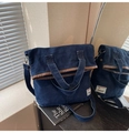 Detalle del bolso vaquero con ribete de cuero marrón y correa ajustable para el hombro - Azul oscuro