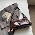Sac hobo marron foncé en cuir ciré avec bandoulière réglable dans un décor de style de vie - Café sans pendentif