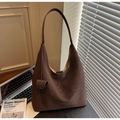 Detail view of large dark brown leather tote with wide strap and pendant ornament - Coffee
