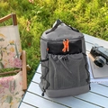 Sac à dos de randonnée gris foncé avec fermetures éclair orange sur une table de camping - Gris