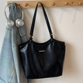 Grand sac cabas noir en similicuir avec détails dorés dans un décor de style de vie - Noir