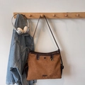 Detailed close-up of brown suede shoulder bag with smooth leather trim and metal ring logo - Brown No Pendant